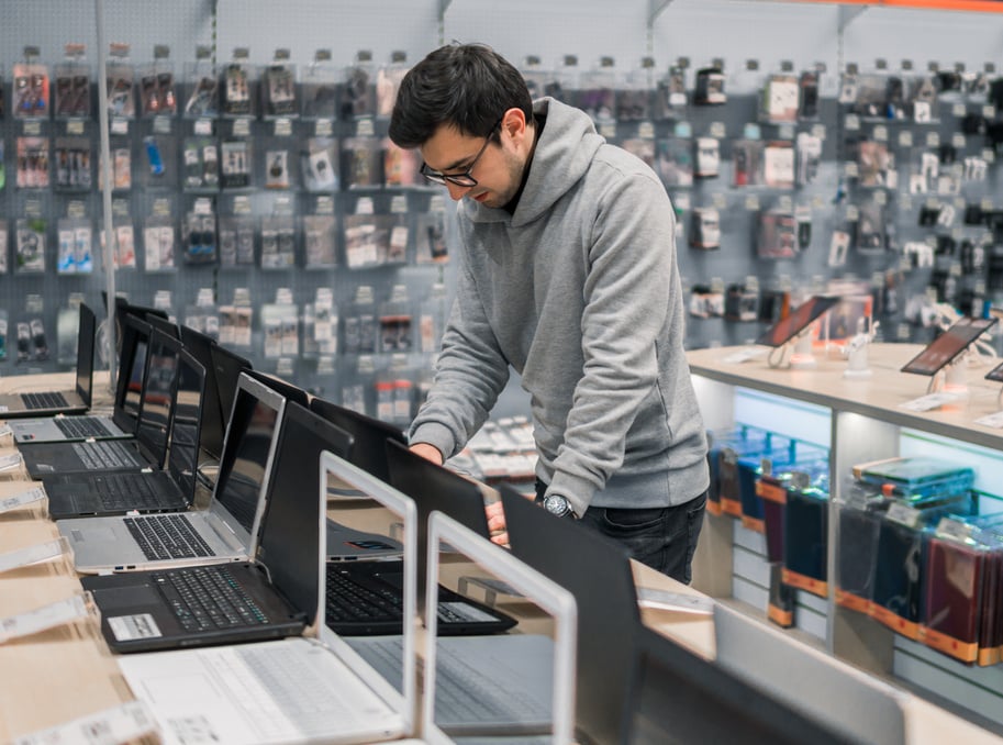 modern male customer choosing laptop in the computer shop